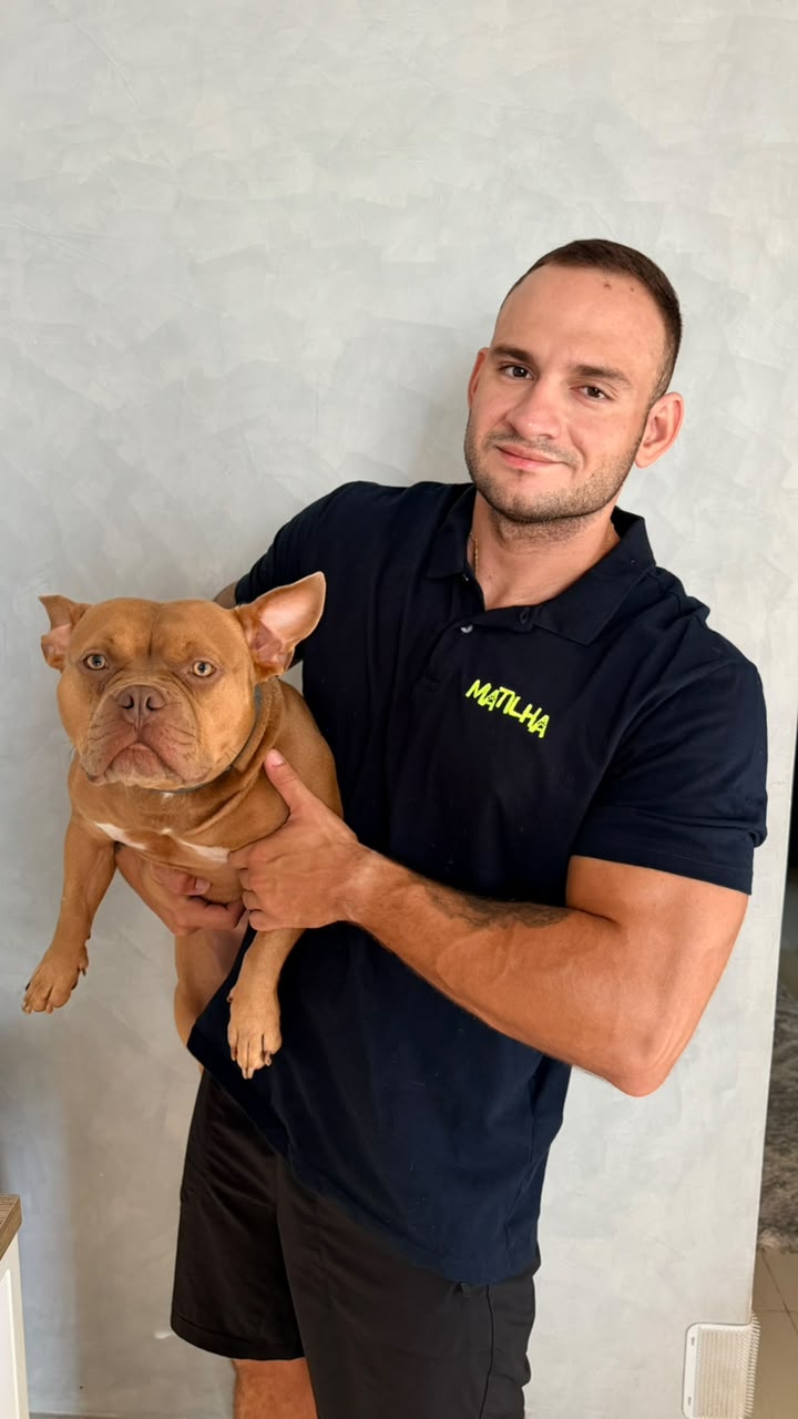 João com um cão no colo, usando o uniforme da Matilha