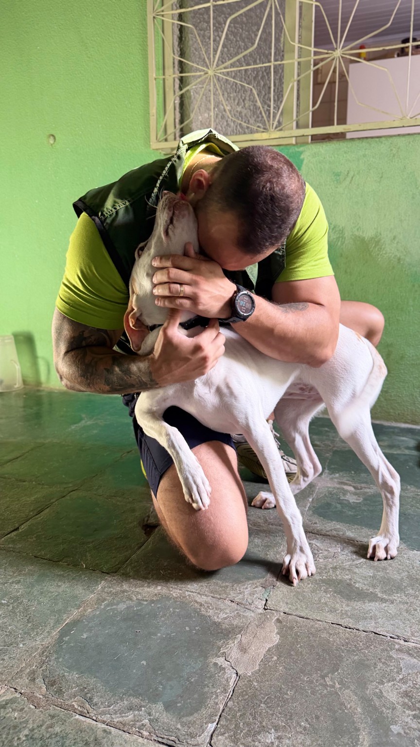 João em momento de vínculo e cuidado com um cão branco