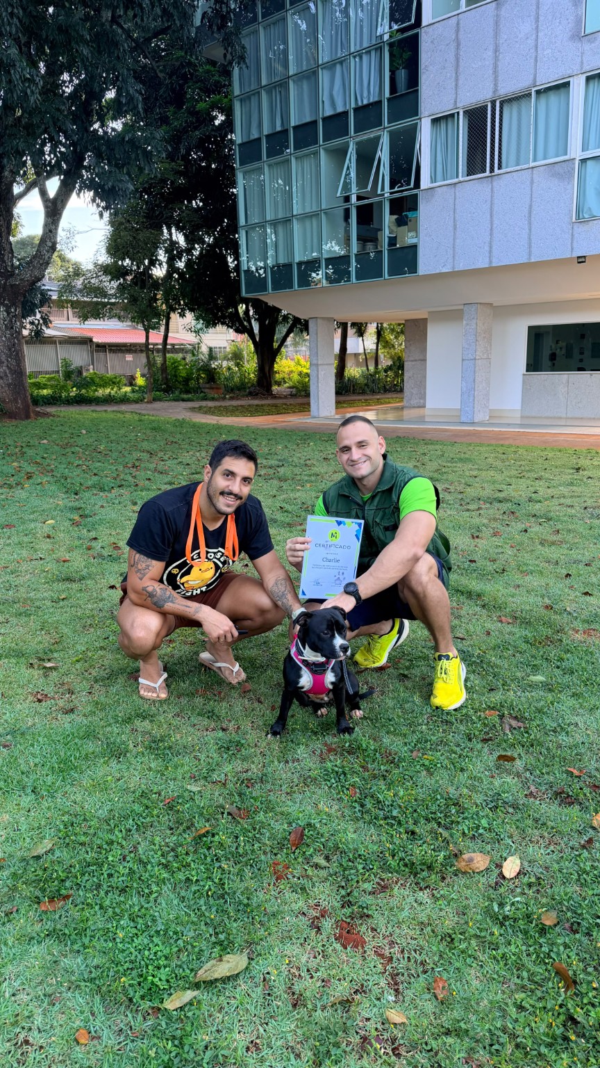 João, tutor, cão e certificado em um registro de conclusão do adestramento
